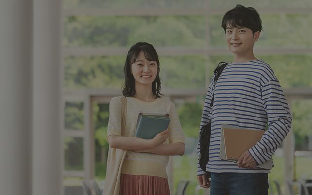 男性と女性がノートを持って立っている